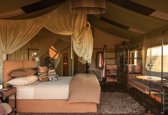 Accommodations at Singita Mara River Tented Camp in Tanzania feature canvas walls and large king-size beds with gauze netting.